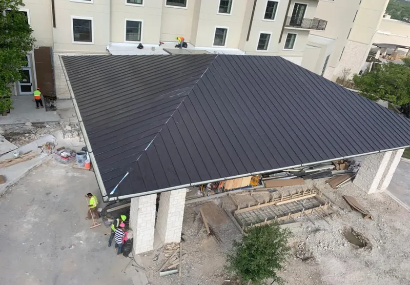 Metal roofing installation team working on a commercial building in Highland